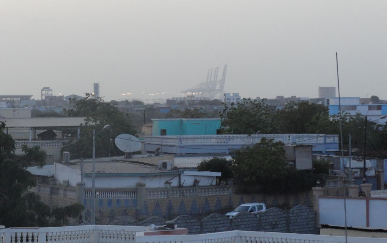 Depuis la terrasse, au fond à droite, les grues du port